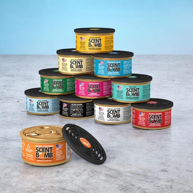 Assorted air freshener cans with black lids stacked in a group.